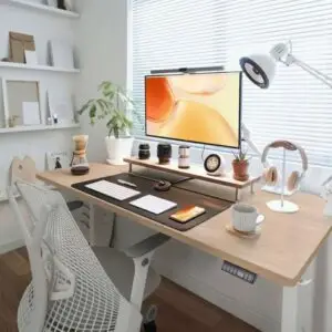 Minimalist home office setup with ergonomic chair, wooden desk, monitor, and modern workspace accessories for productivity and comfort.