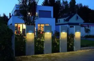 Modern outdoor lighting illuminating a contemporary home exterior with sleek wall fixtures at night