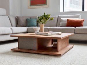 Modern coffee table with wood finish in a stylish living room featuring a gray sofa and decorative accents.