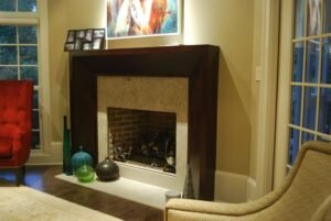 Modern fireplace mantels with sleek dark wood frame and neutral stone surround in contemporary living room