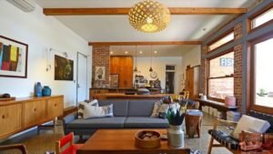 Mid-century modern living room with wooden furniture, exposed brick wall, and cozy gray sofa showcasing perfect Nail Mid-Century style.