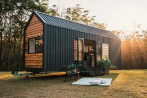 Tiny home with wood and metal exterior sitting on open land at sunset
