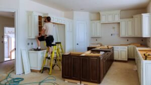 Home Remodeling in Progress – Worker Installing Kitchen Cabinets During Renovation