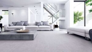 Minimalist furniture in a modern living room with white sofas, gray cushions, and a sleek concrete coffee table